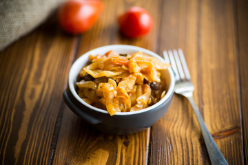 Stewed cabbage on the old wooden background