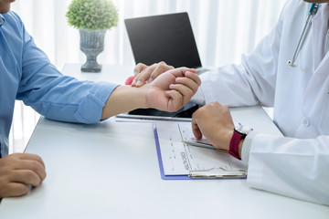 Doctor who is checking the patient's pulse at the wrist.