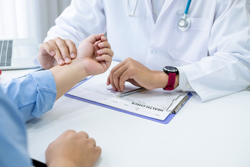 Doctor who is checking the patient's pulse at the wrist.
