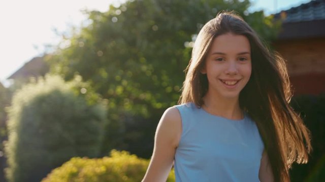 Portrait of a beautiful girl in the sun at sunset looking at camera and smiling freedom cute girl hair lifestyle summer teen attractive calm confident face field young happiness outdoor slow motion