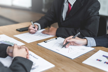 Business people talk about investment, marketing planning and view the data sheet in the financial data graph.