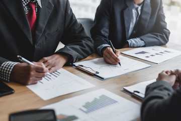 Business people talk about investment, marketing planning and view the data sheet in the financial data graph.