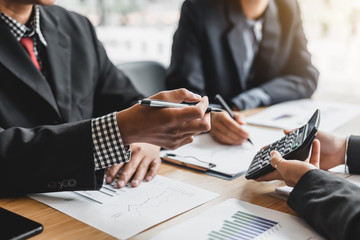 Business woman holding calculator to show their income and business profits at meeting.