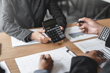 Business woman holding calculator to show their income and business profits at meeting.
