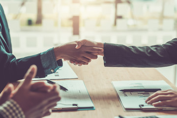 Business people shaking hands and congratulating at meeting.