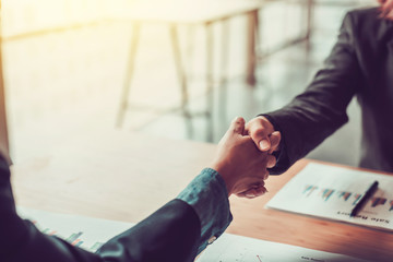 Business people shaking hands and congratulating at meeting.