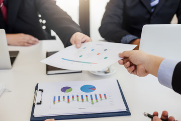 Businessman present graph financial information at the meeting.