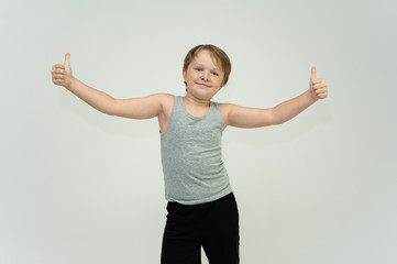 Photo is a waist-high portrait of a fun cheerful cute happy school-age athlete boy in a T-shirt....