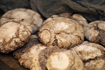 Biscuits with powdered sugar on a wooden plate close up