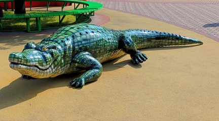 the figure of a crocodile near the Park bench
