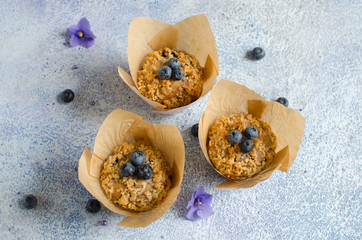 Homemade muffins with fresh blueberries and crumble topping on blue background