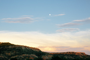 palo duro canyon at sunset, clouds and moon in sky, dessert horizon 