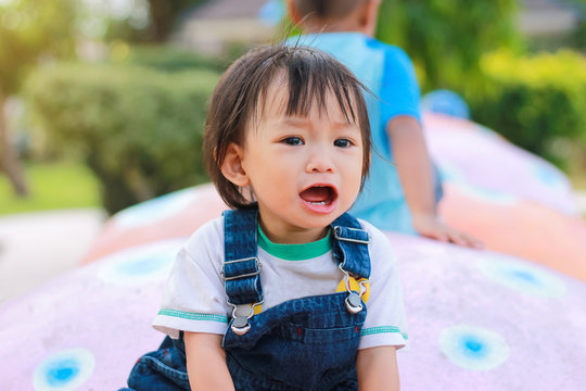 Portrait image of 1 years and 4 months olds baby girl. Asian child girl crying when she playing with the toy at the playground. Expression and emotions of baby concept.