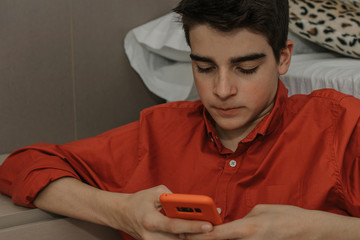 young teenage boy with mobile phone at home