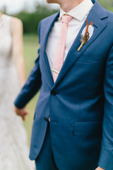 Groom holding hands with bride, groom leading the way, walking together