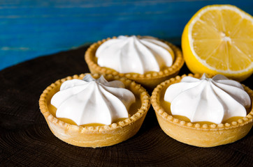 White aircake with lemon filling and lemon on a wooden table