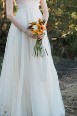 bride holding small wedding bouquet, poppies and peonies, orange and white