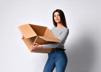 beautiful brunette woman standing on a light background with a moving cardboard box