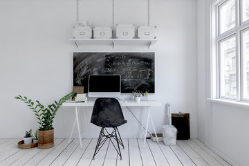 Modern monochromatic white office with blackboard