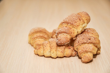 freshly baked croissants on a light wooden table