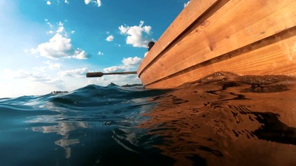 man is sailing in a boat rowing oars. Camera by the water. Boat trip.