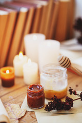  homeliness, hygge, candles, old books, diary and dried flowers on a wooden background, vintage
