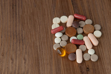 Selective focus on pill spread on wooden background. Global healthcare concept. Pharmaceutical industry. Drugs in medical container on wooden background