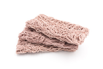 Three stacked rectangular dry Purple noodles are the staple food in China on a white background.