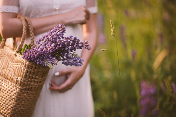 Women hands holding a basket with wildflowers