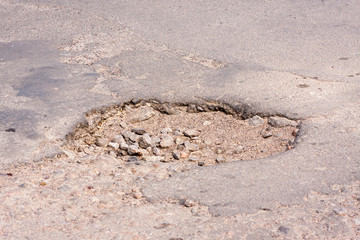 Bad roads. Hole in the asphalt, the risk of movement by car, bad asphalt, dangerous road, potholes in asphalt, pit unsafe hole road concept. Way markings in the pit.