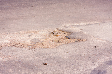 Bad roads. Hole in the asphalt, the risk of movement by car, bad asphalt, dangerous road, potholes in asphalt, pit unsafe hole road concept. Way markings in the pit.