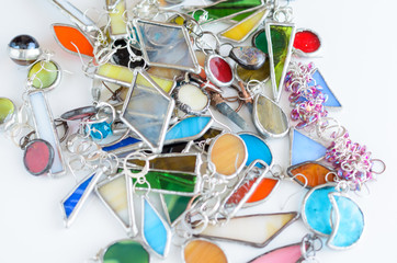 Assorted earrings in various colors of glass and metal. Selective focus. Bijouterie texture background.