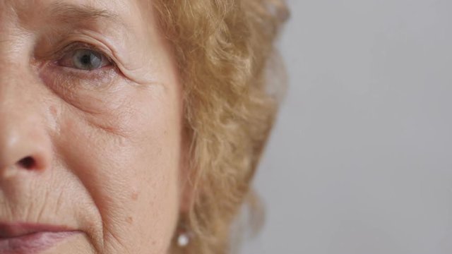half face of an elderly serious woman looking straight, sad and tired granny's sight, concept people age and health