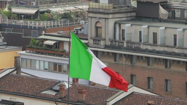 Italian flag waving in the wind in Italy, Milan. Closeup, selective focus.