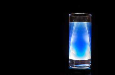 x-railike lighted glass of cocktail on black background