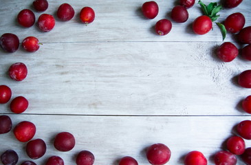 Fototapeta na wymiar background with plum berries light wood texture
