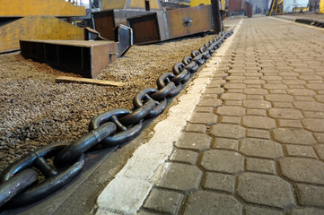 Fototapeta premium A large and long chain lies in the passage in the workshop.