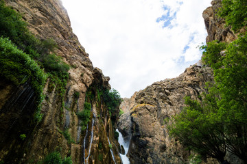 waterfall in the mountains with clouds