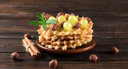 .waffles with grapes and nuts on a wooden background