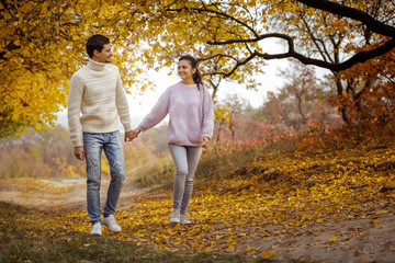 Couple in love has happy moments and enjoying beautiful autumn day in park.