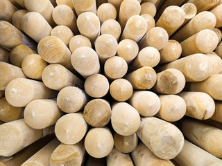Group of new wooden shafts for garden tools in a store, inventory sticks background.