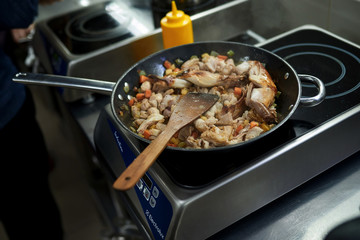 cooking in a pan with stove and cook