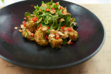 Shrimp in batter on a black plate