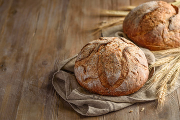 Homemade whole grain bread with flax seeds on a wooden background. Copy space 