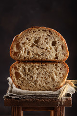 Freshly baked homemade whole grain bread with flax seeds. Cut bread  on a dark background. Close-up