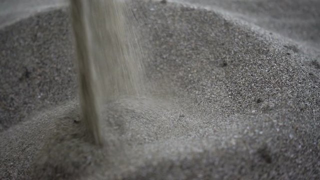 Slow motion sand trickle pours and forms a hill.	