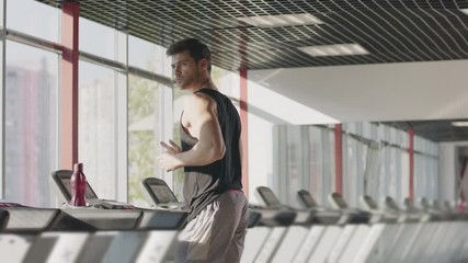 Runner man training on treadmill machine at workout in fitness center