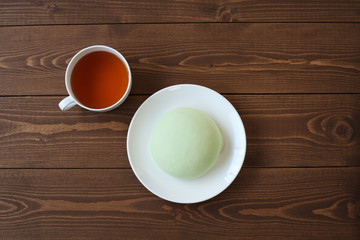 お皿にのせた メロン パン 紅茶 木のテーブル