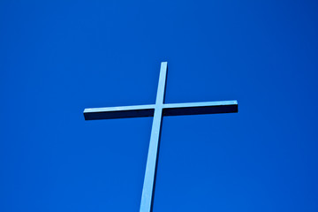 A blue cross of a church towards the blue sky in Bavaria, Germany