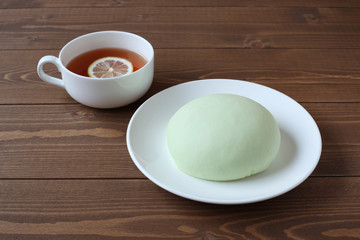 お皿にのせた メロン パン レモンティー 木のテーブル